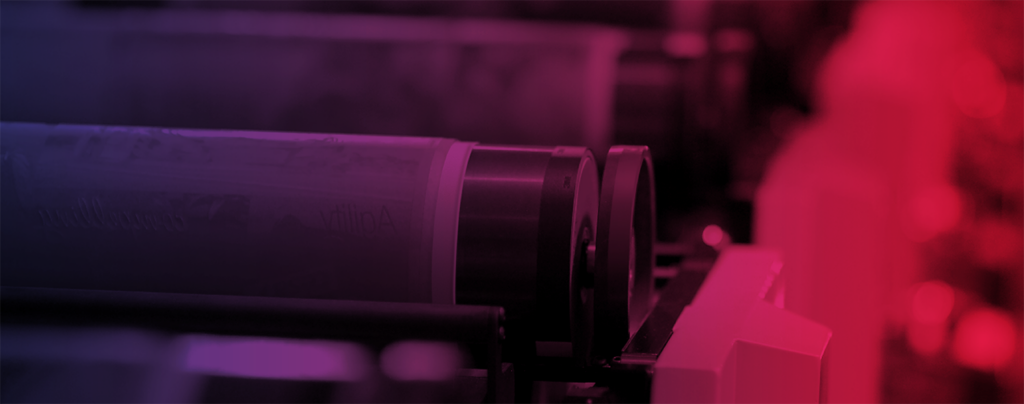 Close-up view of industrial rollers on a machine, with a red and purple color overlay.