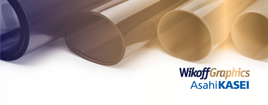 Four rolls of printing film or material are displayed horizontally on a white surface, with the Wikoff Graphics and Asahi Kasei logos in the bottom right corner.