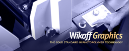 A person operates a machine with control knobs and buttons, accompanied by the text "Wikoff Graphics: The Gold Standard in Photopolymer Technology.