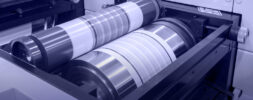 Close-up view of two metal rollers inside a printing press or industrial machine.