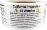 A roll of labels displaying a California Proposition 65 warning about chemicals known to cause cancer, birth defects, or other reproductive harm.