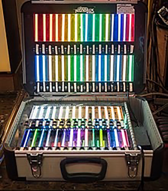 An open case displaying three rows of colorful neon light tubes, arranged horizontally and illuminated in various colors.