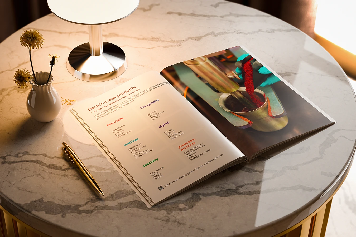 An open magazine on a marble table next to a gold pen, a small vase with dried flowers, and a modern lamp, with sunlight illuminating the scene.