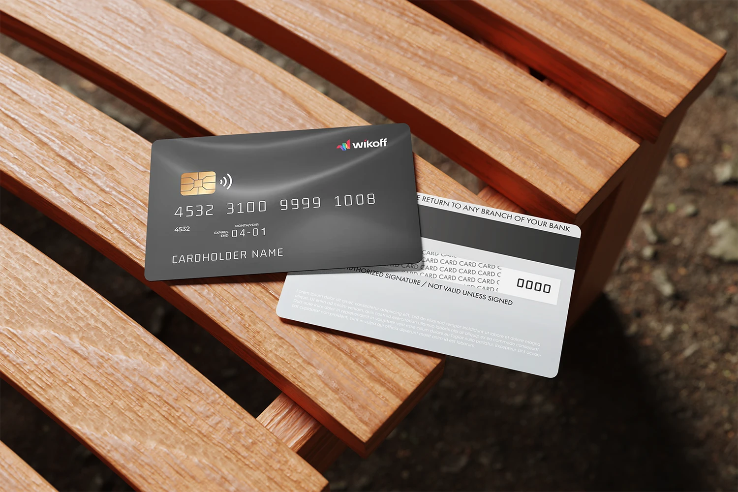 A black credit card and its reverse side rest on a wooden bench, displaying card details and instructions.