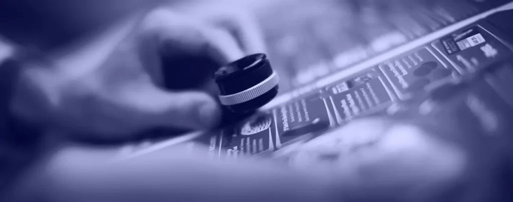 A hand uses a magnifying glass to closely examine printed text and images on a sheet of paper.