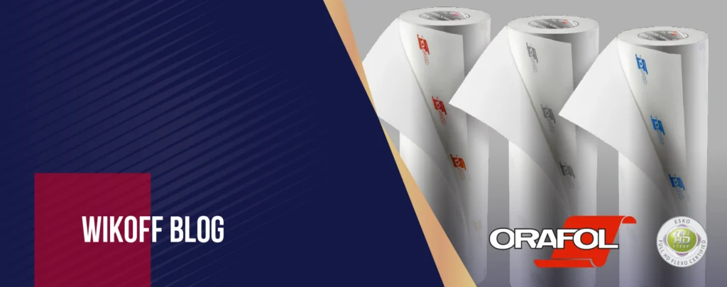 Three rolls of Orafol branded printing material stand upright on the right, with "Wikoff Blog" text on a dark blue and red background on the left.