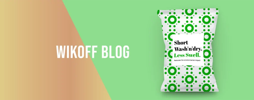 A green and white packet labeled "Short Washndry. Less Swell." is displayed on a green background next to the text "Wikoff Blog" on a gradient brown and green backdrop.