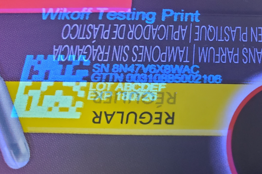 A close-up of a label showing the words “REGULAR,” “SN,” “LOT,” “EXP 10/2026,” and other alphanumeric codes, with some text printed upside down.