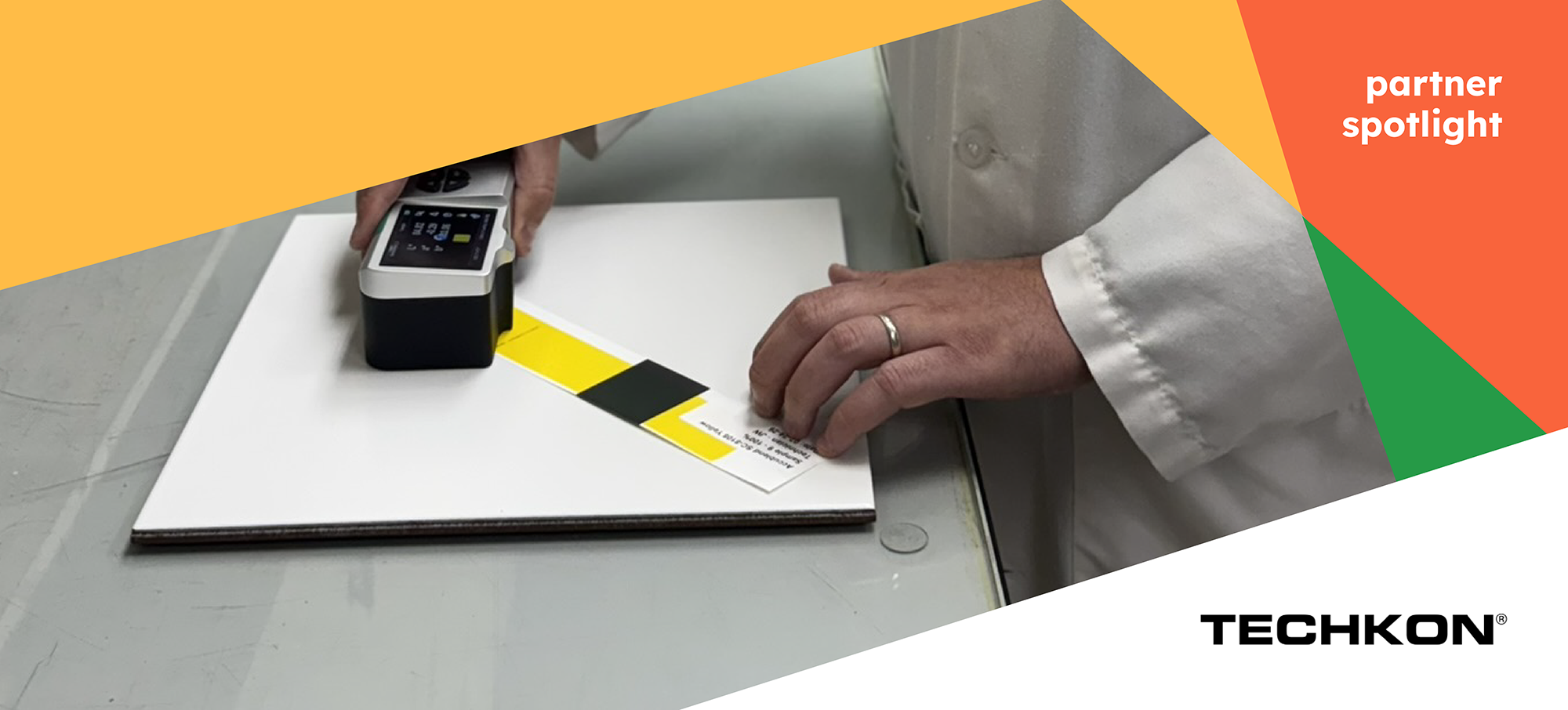 A person in a lab coat measures color accuracy on a printed sheet with a handheld device. TECHKON and “partner spotlight” text appears on the image.